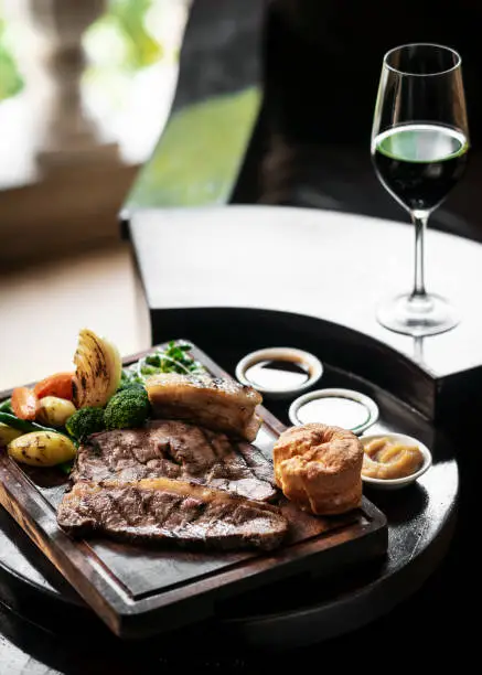 Photo of gourmet sunday roast beef traditional british meal set on old wooden pub table