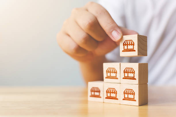 istock Franchise business marketing system concept. Structure service store network strategy. Hand putting wooden block on top with icon store 1279785365