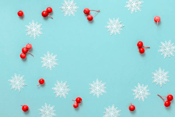 istock Xmas pattern. White snowflakes, red berry in Christmas composition on pastel blue background for greeting card. Flat lay, top view, copy space. 1279785593
