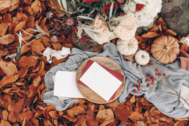 istock Autumn wedding, birthday mockup scene. Floral bouquet with olive branches, mums, hydrangea and pink rose flowers. Blank paper cards on wooden plate. Red beech leaves and muslin runner. Selective focus 1279786651
