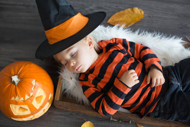 istock Baby boy, sleeping in a basket, halloween decoration around him 1279787501