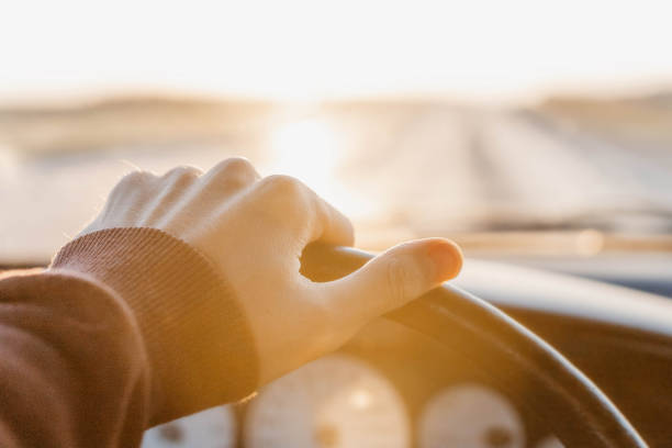 istock concept of working as a driver, hand on the steering wheel at sunset. 1279789244