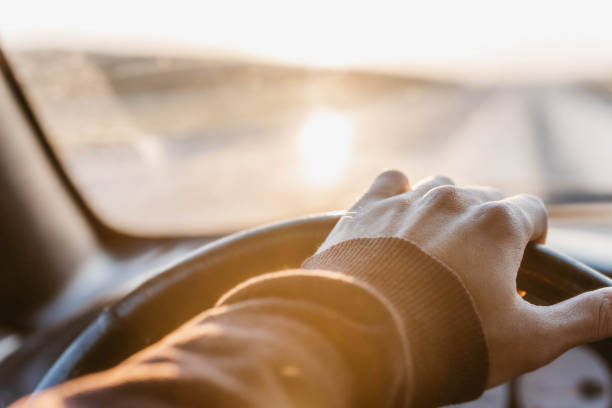 istock concept of working as a driver, hand on the steering wheel at sunset. 1279789254