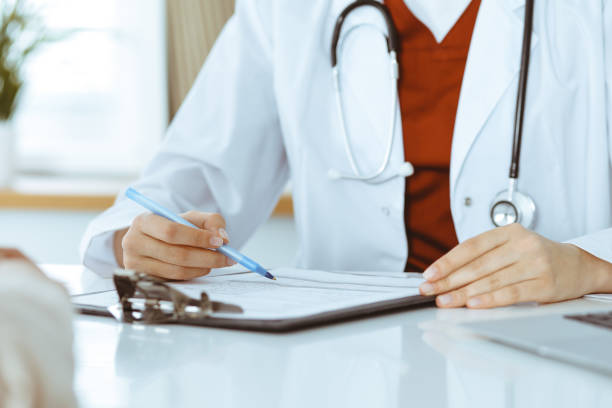 istock Unknown woman-doctor consulting patient and using clipboard with a medication history record. Medicine concept 1279792044