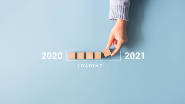 loading new year 2020 to 2021 with hand putting wood cube in progress bar. - determination new years eve list aspirations imagens e fotografias de stock