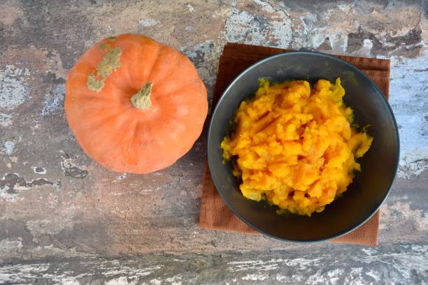 istock Pumpkin puree in a bowl with fresh pumpkin. Flat lay 1279796211