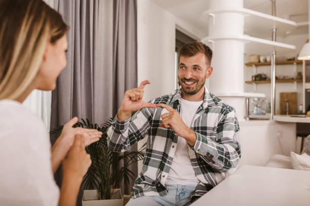 istock Young couple talking using sign language at home. 1279796385