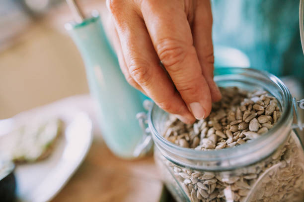 istock A woman's hand takes sunflower seeds from a jar 1279798730