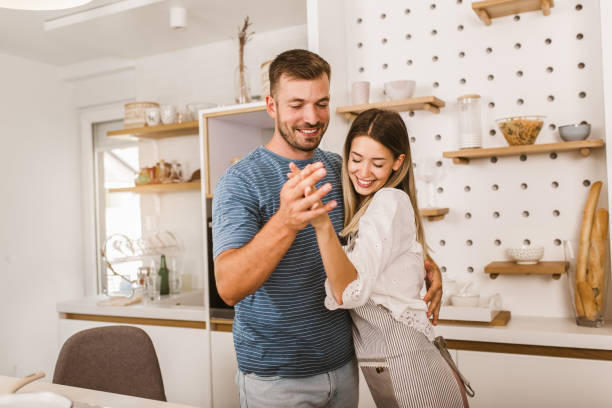 istock Young beautiful couple in kitchen having fun. 1279799472