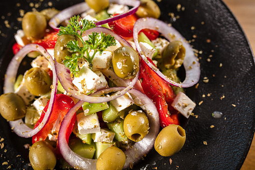 Close-up of bowl of Greek salad. Tomatoes, feta cheese, olives, cucumber and red onion