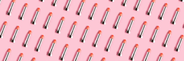 Banner made frompattern with coral lipsticks on pink background.