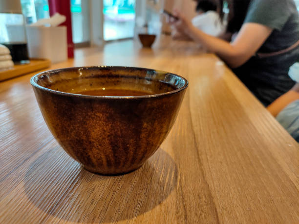 brązowa filiżanka herbaty umieszczona na drewnianym stole. azjatycki smak. rozmyte tło jest gościem restauracji. - variation bamboo black bowl zdjęcia i obrazy z banku zdjęć