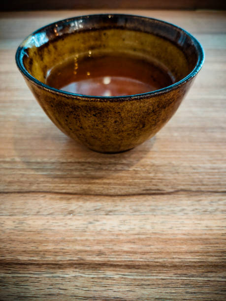 brązowa filiżanka herbaty umieszczona na drewnianym stole. azjatycki smak. ponad wygląd. zdjęcie pionowe. - variation bamboo black bowl zdjęcia i obrazy z banku zdjęć