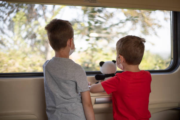istock Rare view of brothers enjoying train journey 1279802584