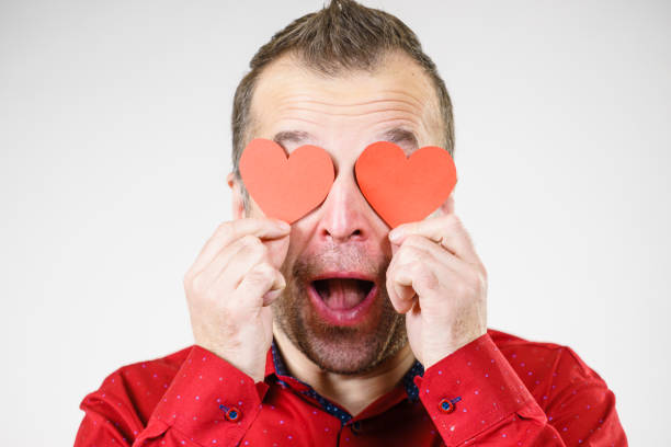 istock Man in love with hearts on eyes 1279803533