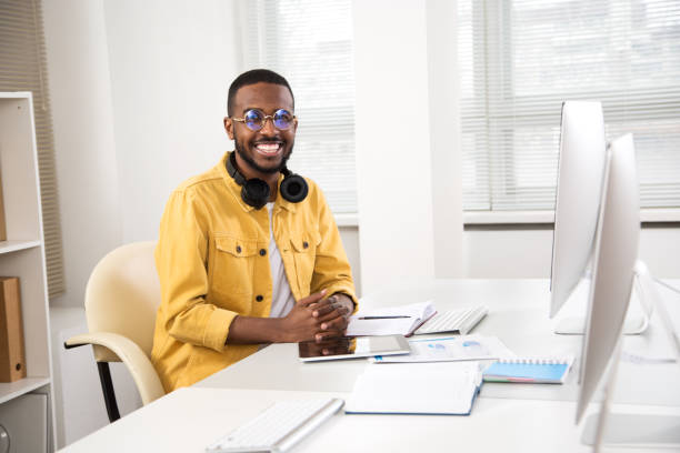istock Happy african american creative businessman smiling while looking at camera in office 1279804044