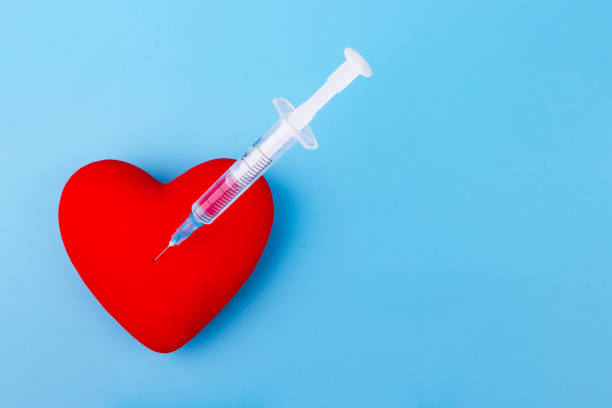 istock Red heart and a syringe on blue background 1279805091