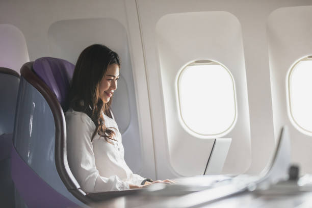 istock Asian young woman using laptop sitting near windows at first class on airplane during flight,Traveling and Business concept 1279806352