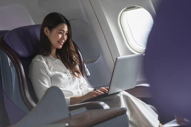 istock Asian young woman using laptop sitting near windows at first class on airplane during flight,Traveling and Business concept 1279806385