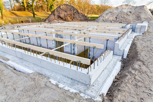 Dutch construction site with foundation for new house to be built. Here a concrete construction was built in the ground. There will be created several rooms under the ground and the rest above the ground.