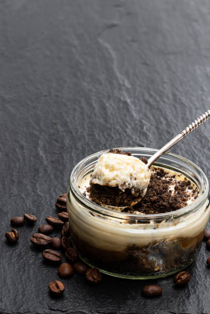 istock Layered creamy cappuccino cheesecakes in glass jars isolated on white 1279807011