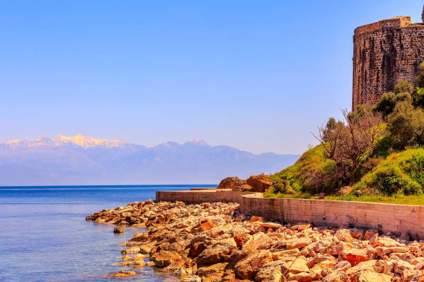 Sunset sea view, old castle wall and mountain snow peaks panorama in Messinia, Peloponnese, Greece