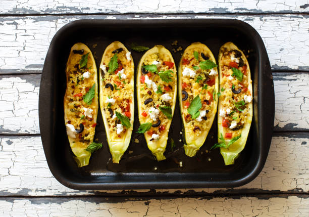 istock Eggplants stuffed with couscous vegetables, soft cheese and olives on black baking sheet 1279808636