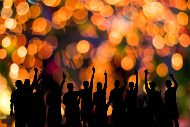 istock Siluette men raise their hands with orange bokeh. 1279810014