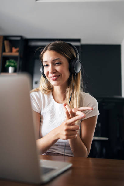 Attractive young teacher teaching online class Young pretty teacher is teaching online class. She is counting fingers, explaining mathematics educational subject stock pictures, royalty-free photos & images