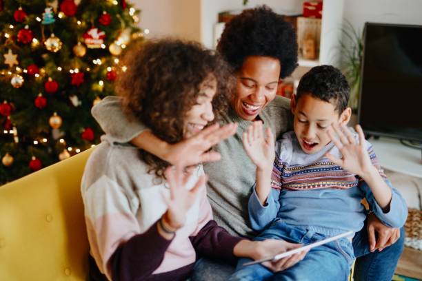 videoanruf mit familie am weihnachtstag während der pandemie - weihnachten familie stock-fotos und bilder