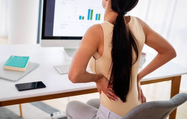 istock Overworked woman with back pain in office with bad posture 1279812536