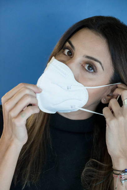 istock YOUNG WOMAN PUTTING ON HER PROTECTIVE MASK 1279815410
