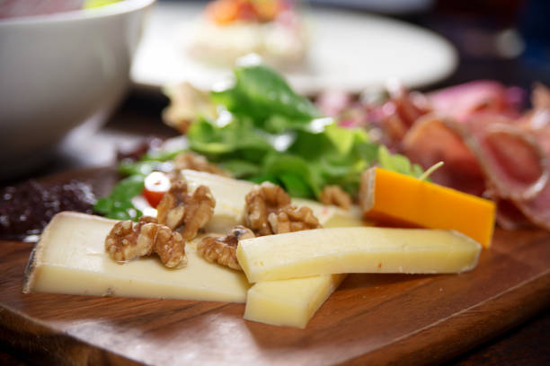 close up of cheese , walnut and meat board