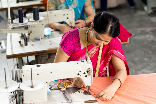 Indian women textile workers using sewing machine on production line