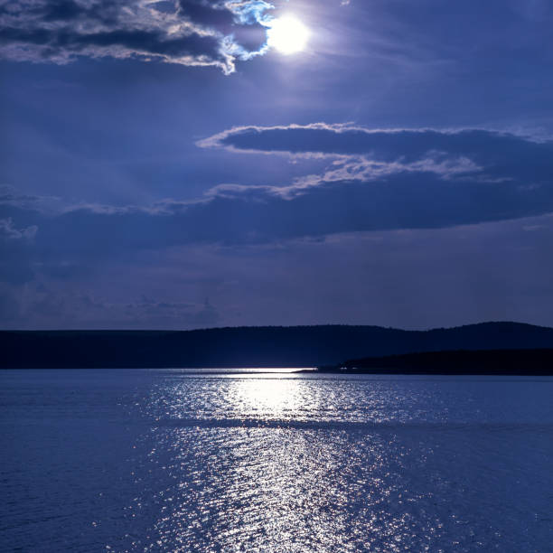 istock Night landscape of lake, sky with cloud and full moon. Moonlight path reflection 1279819470