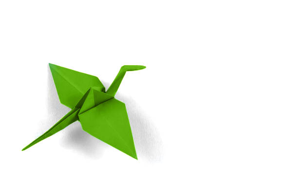 istock Green origami crane on white background. 1279820356