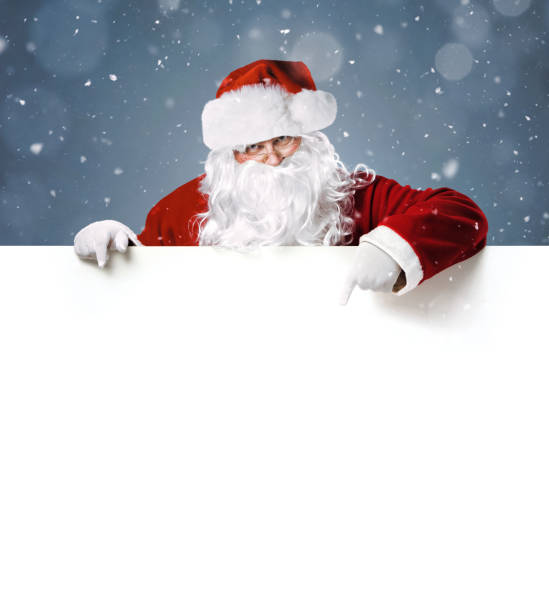 happy santa claus pointing in blank white advertisement banner - pai natal imagens e fotografias de stock