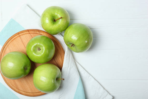 istock juicy green apples on a wooden table. 1279821903