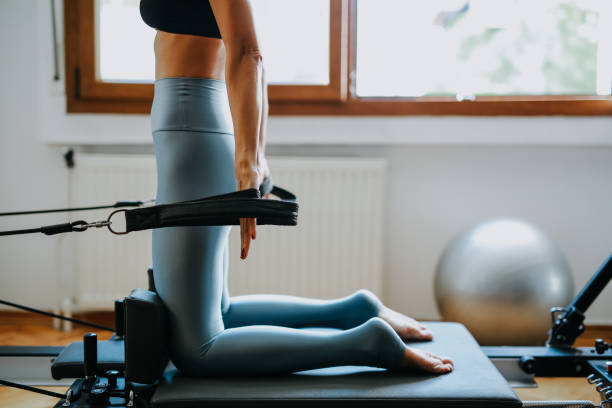 필라테스 요가를 연습하는 젊은 스포티 한 매력적인 여자 - pilates machine 뉴스 사진 이미지