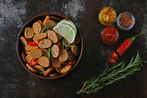хрустящие ржаные крекеры в миске со специями. - crouton fried bread vegan food bowl стоковые фото и изображения