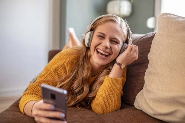 istock Beautiful young woman using smart phone at home 1279824365