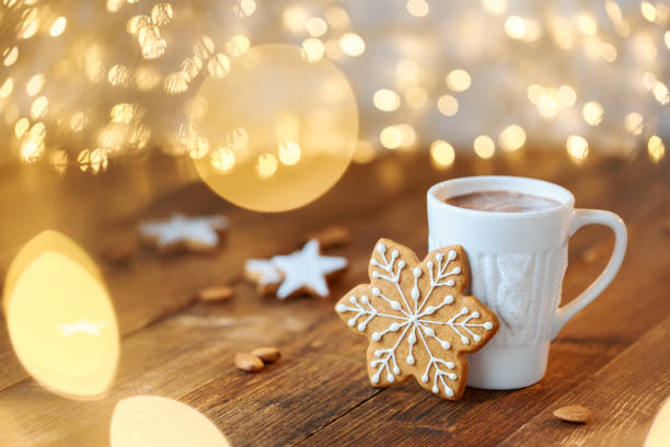 White cup filled with hot chocolate A beautiful white mug with a knitted print and a ginger cookie with icing in the shape of a snowflake on a background of garlands marshmallow photos stock pictures, royalty-free photos & images