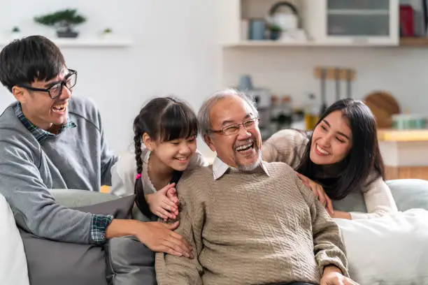 Group Portrait of Happy multigenerational asian family sit on sofa couch in living room with smile. Muti genration family happiness concept.