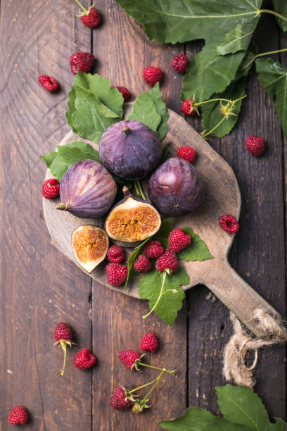 istock Fresh ripe figs on dark table. Healthy mediterranean fig fruit. Fresh figs on black background 1279827235
