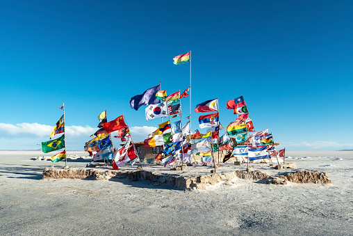 International flags in the Uyuni salt flat desert on the location of the first salt hotel, Bolivia.