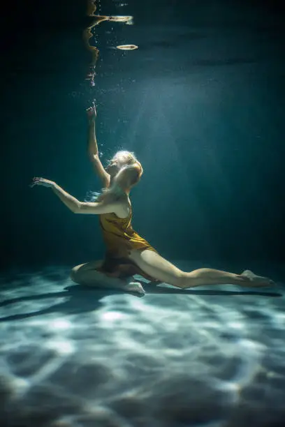 Photo of Beautiful woman in a Golden Dress Underwater