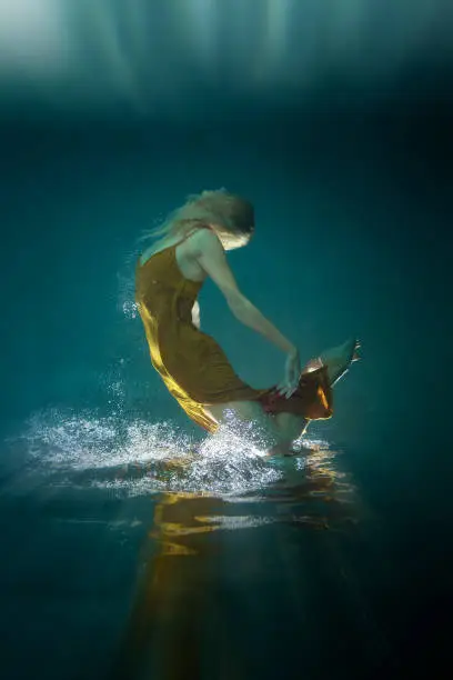 Photo of Beautiful woman in a Golden Dress Underwater