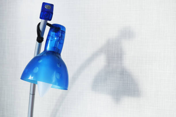 Element of a broken blue table lamp, lamp reflecting on the wall.