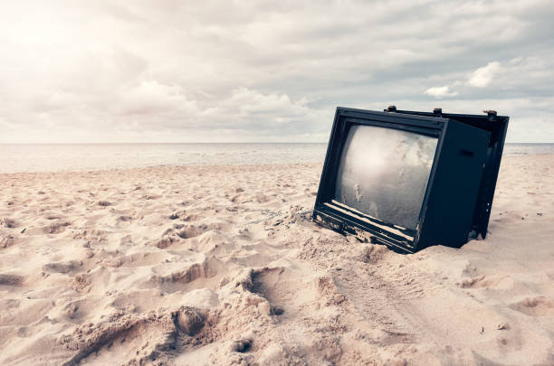 istock Old broken TV set on a beach at sunset. 1279836640