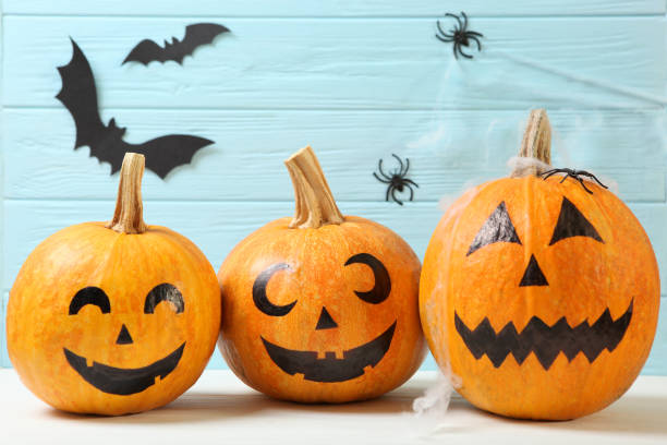 istock pumpkins with painted faces on a colored background for Halloween. 1279837137